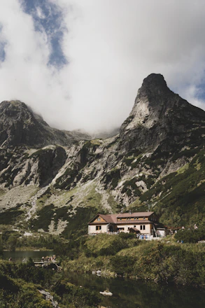 A serene mountain lodge nestled among pine trees under a clear blue sky.