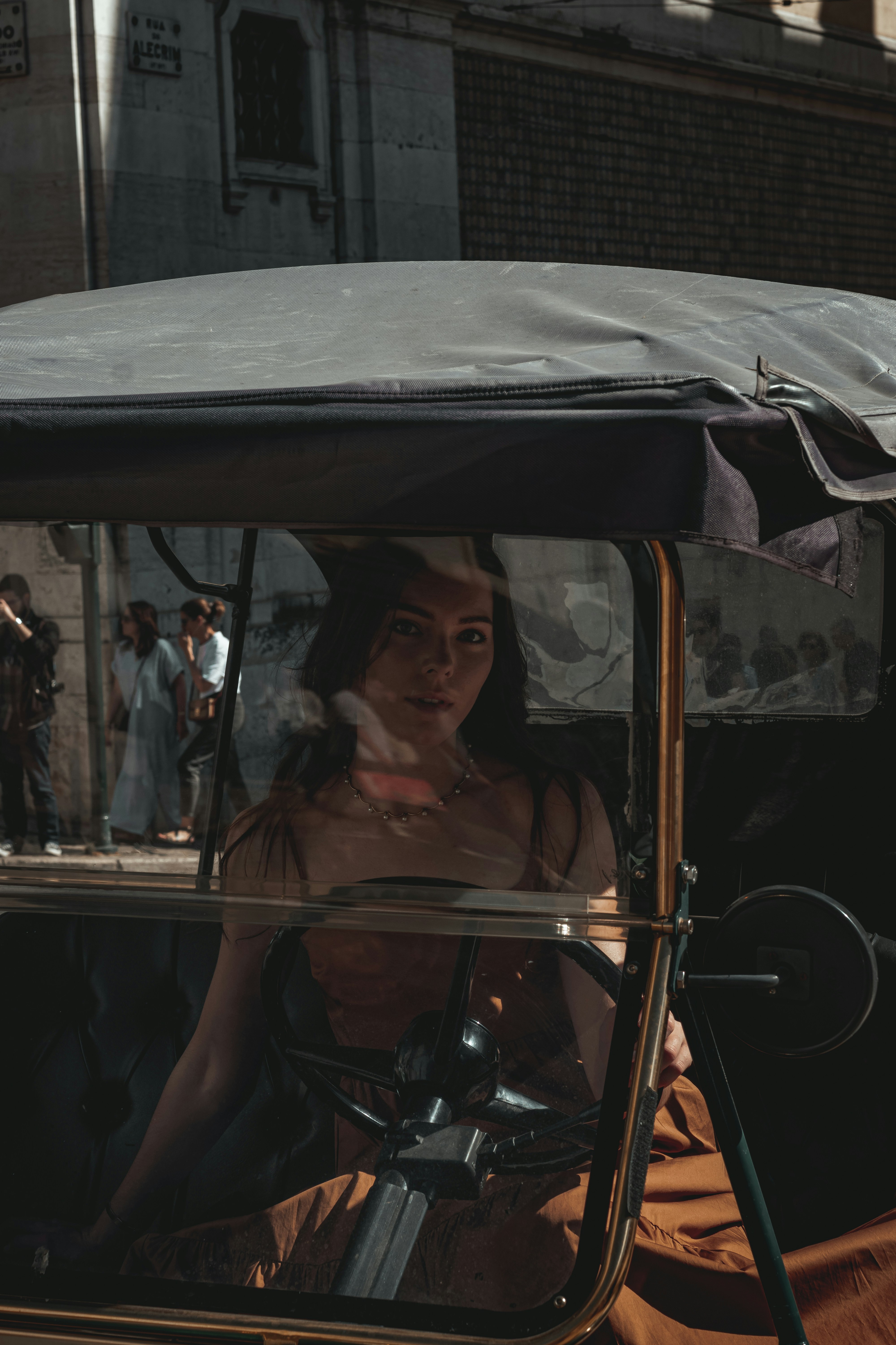 a woman sitting in a buggy on a city street