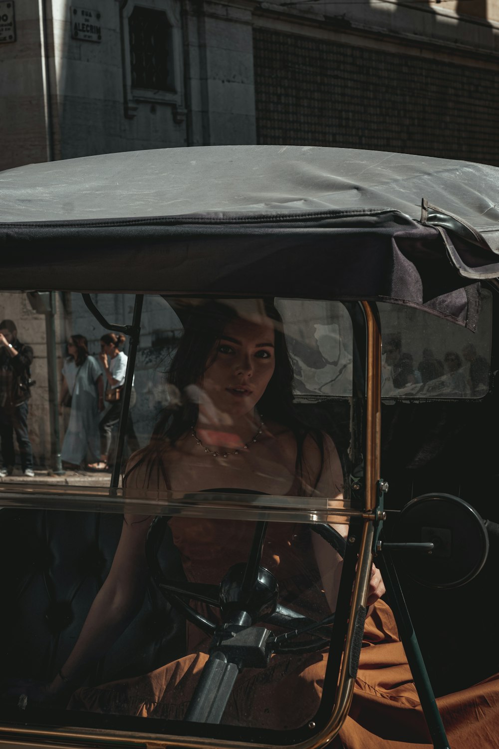 a woman sitting in a buggy on a city street