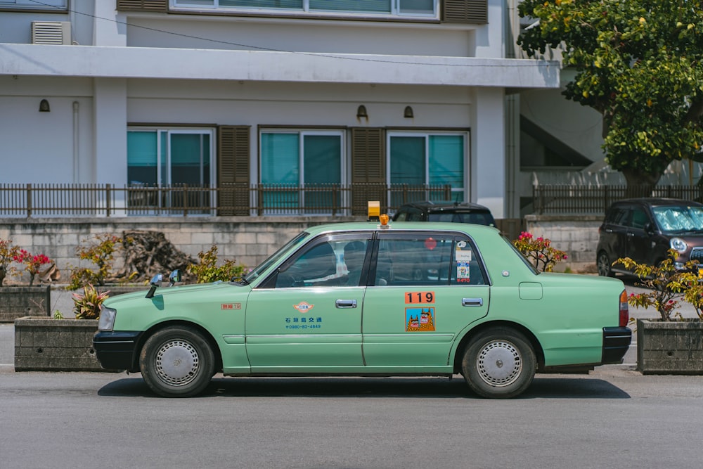 a green taxi cab parked in front of a building
