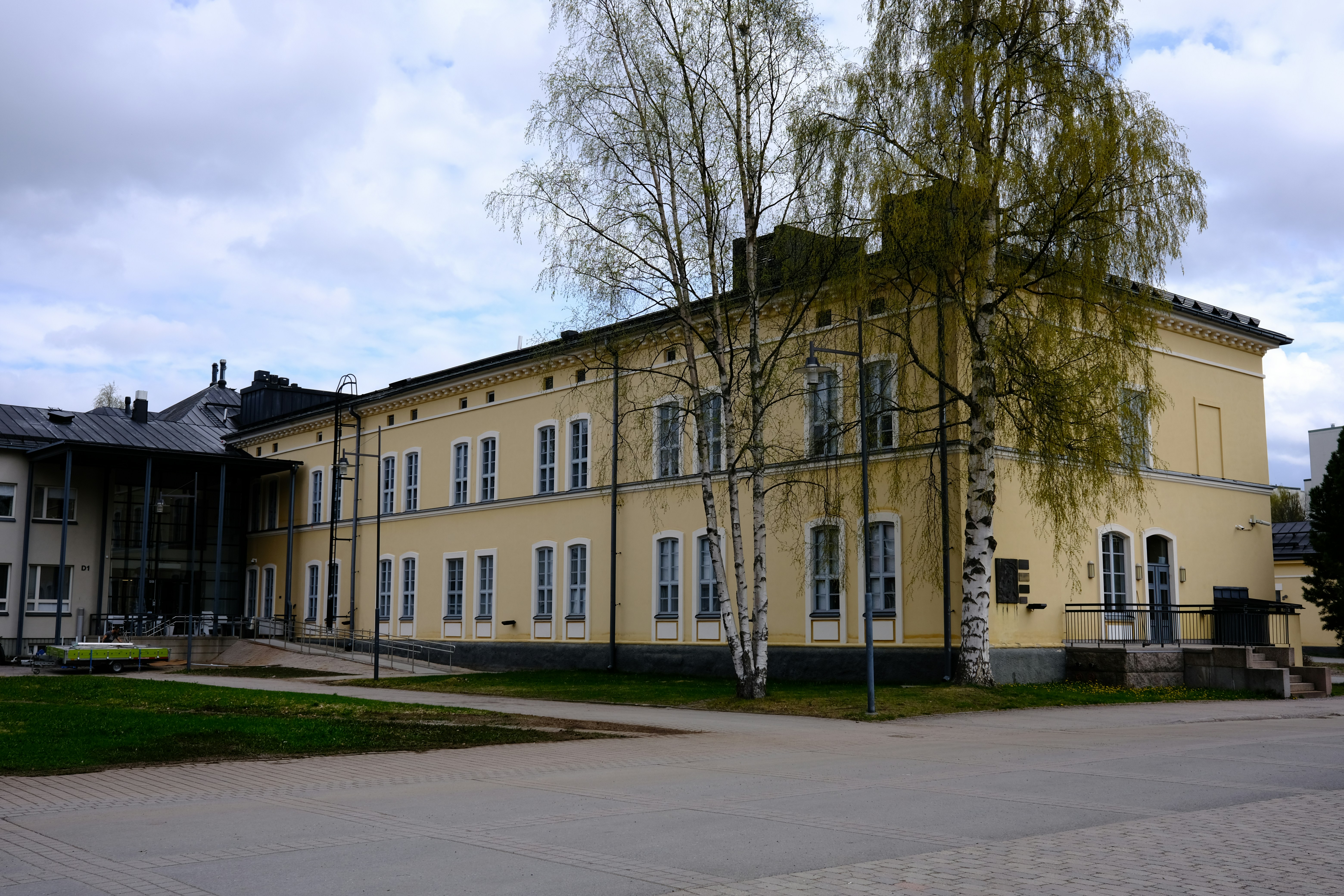 a large yellow building with a tree in front of it