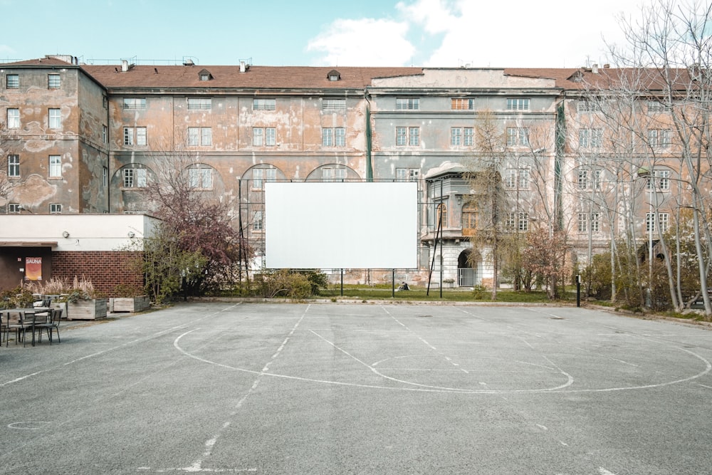 an empty basketball court in front of a building