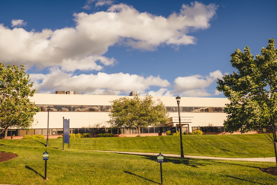 a building on a hill with trees and grass in front of it,