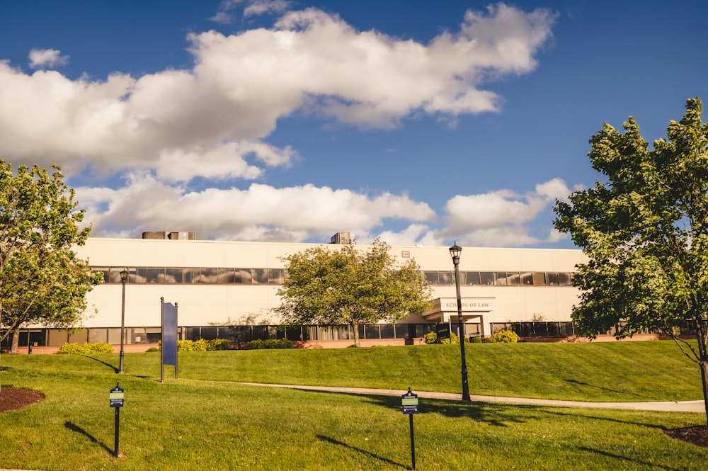 a building on a hill with trees and grass in front of it