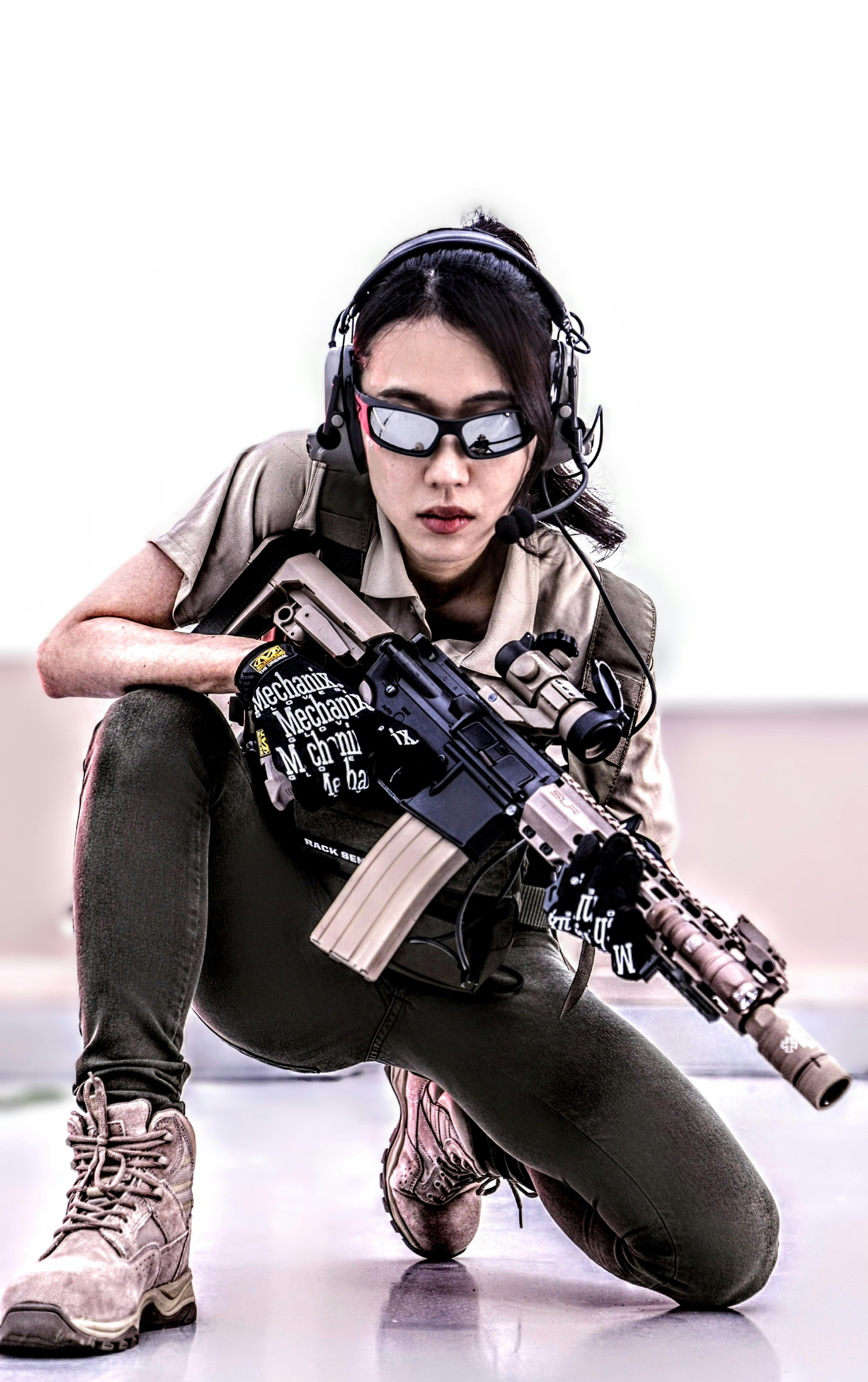 Seorang wanita berlutut dengan pistol di tangannya
