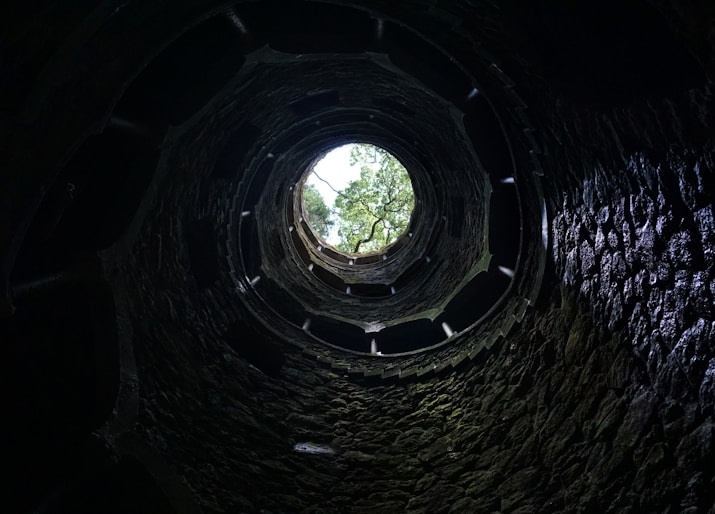 a dark tunnel with a tree in the middle