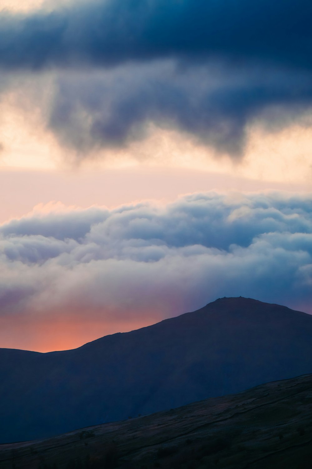 a view of a mountain with clouds in the sky