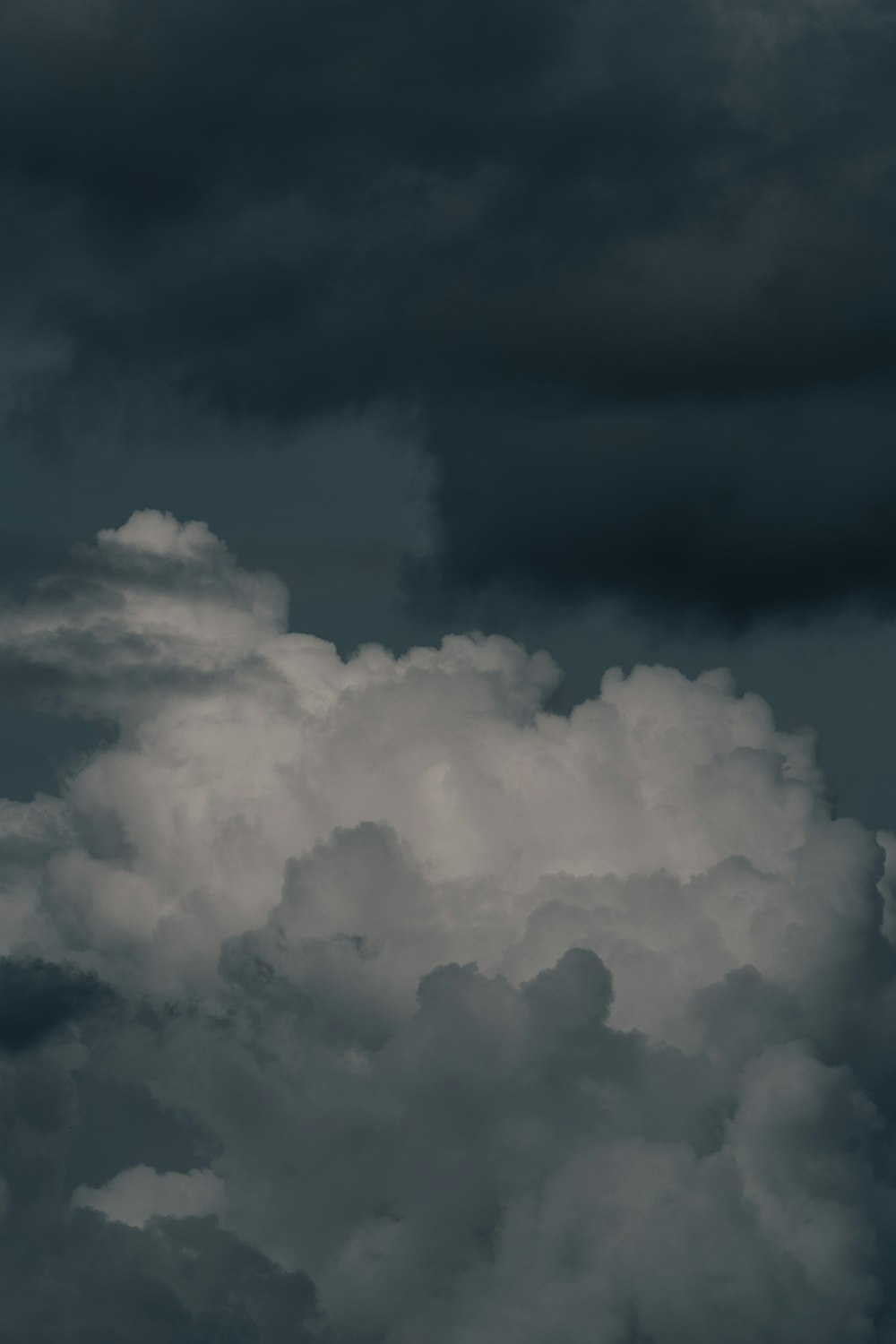 a plane flying through a cloudy sky on a cloudy day