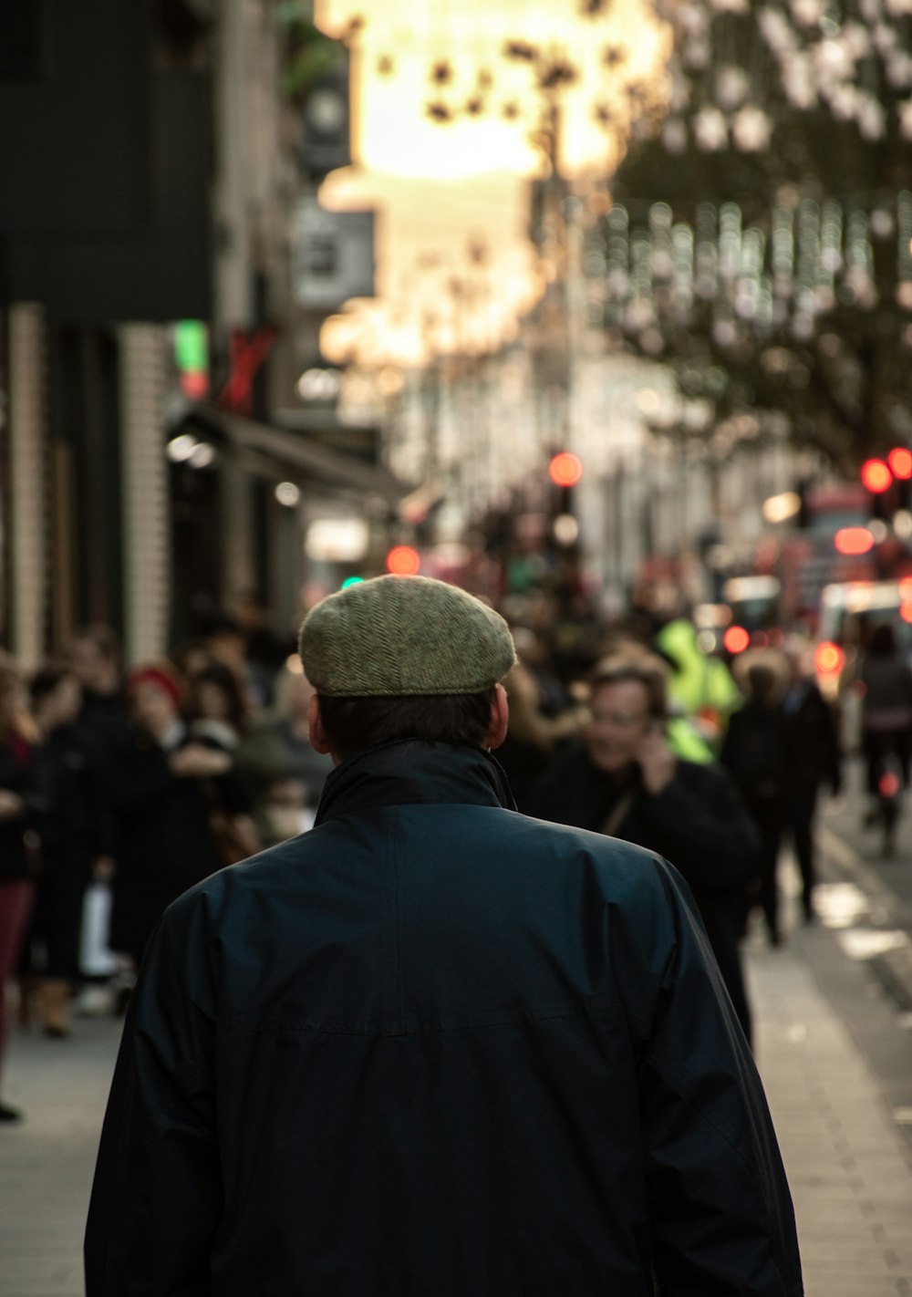 a man walking down a street next to tall buildings