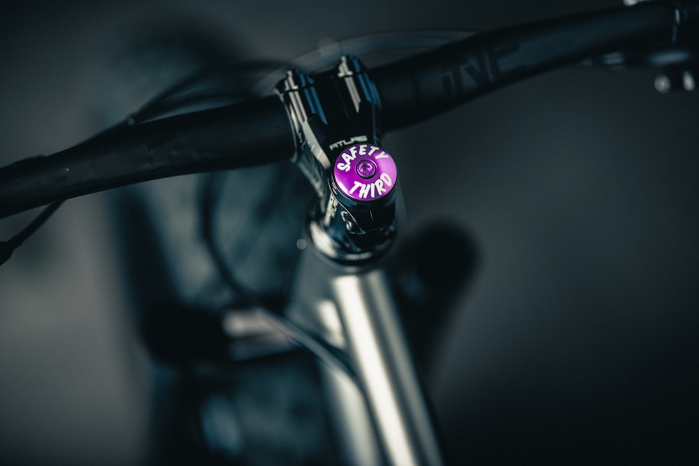 a close up of a bike handlebar with a purple sticker on it