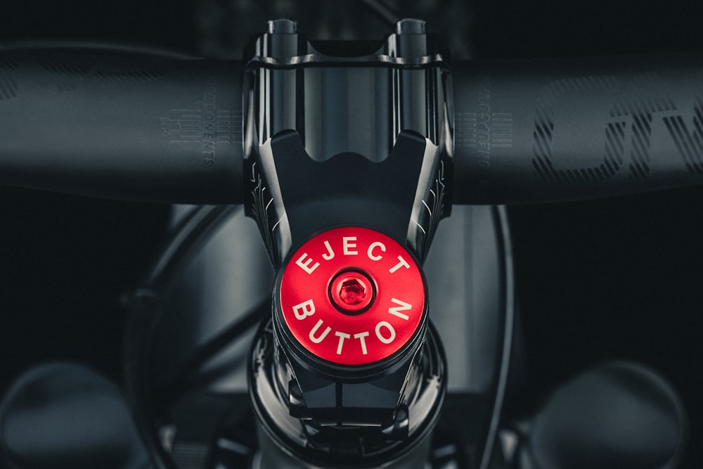 a close up of a red button on a bike