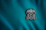 a close up of a blue fabric with a metal emblem on it