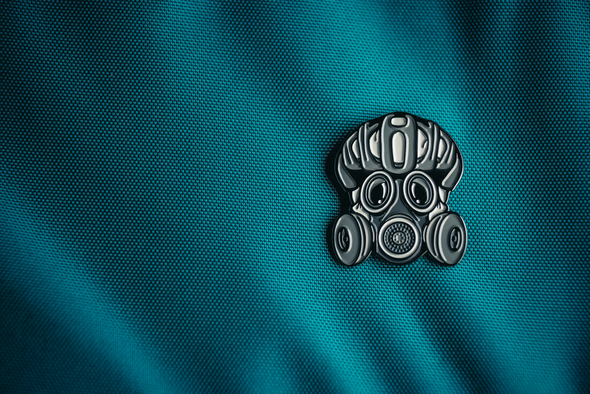 a close up of a blue fabric with a metal emblem on it