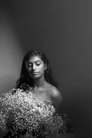 A serene portrait of a woman in quiet reflection surrounded by soft white and rose pale colors