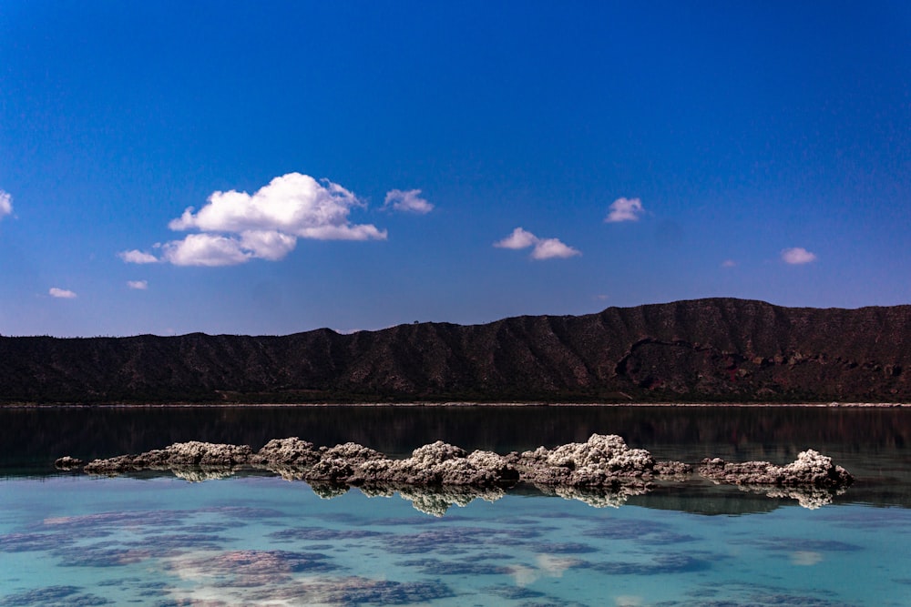 a body of water with a mountain in the background