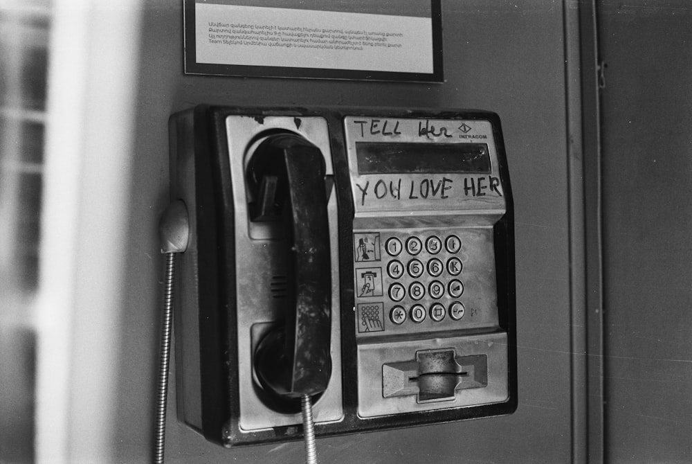 an old fashioned pay phone with writing on it