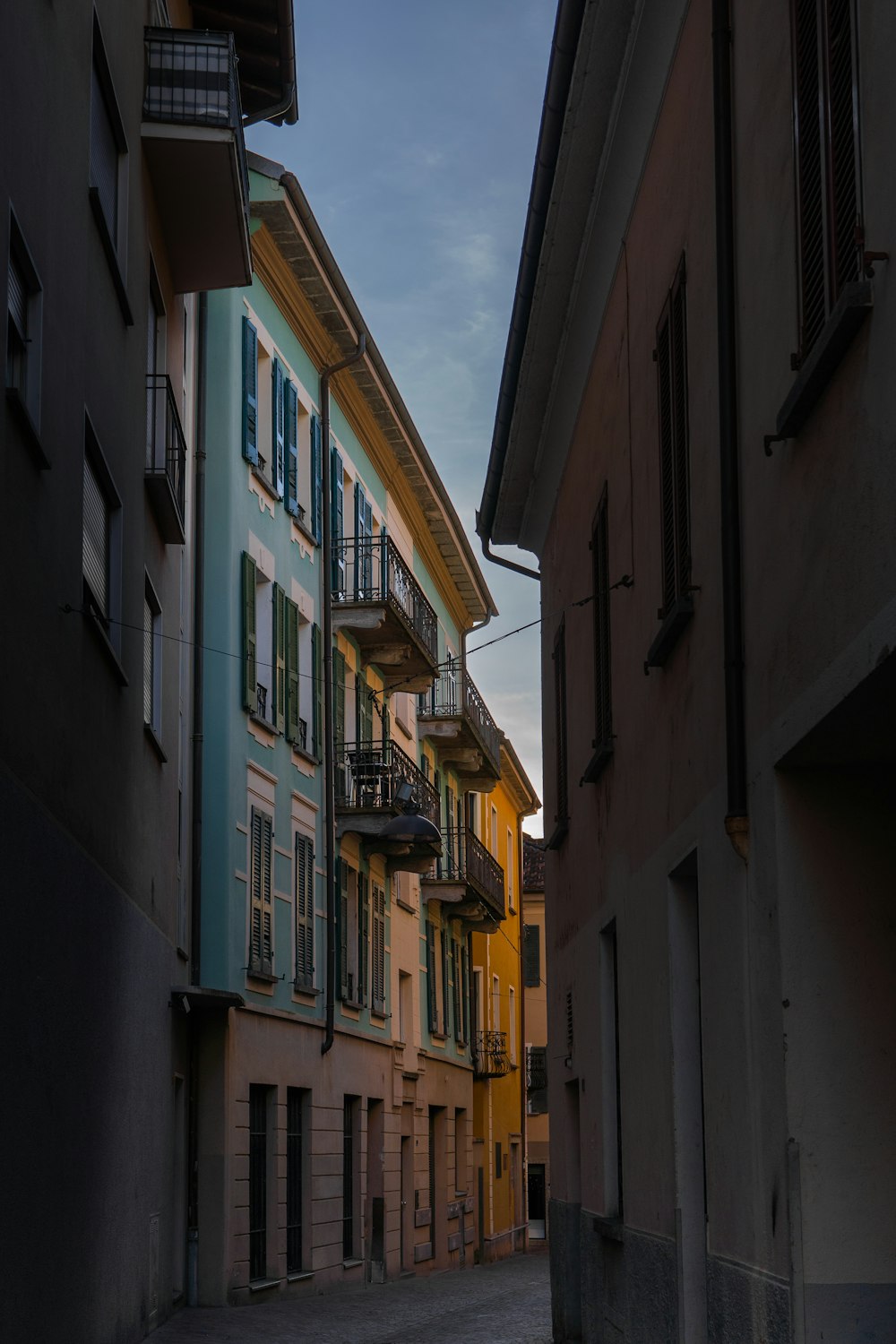 a narrow alley way with buildings and balconies