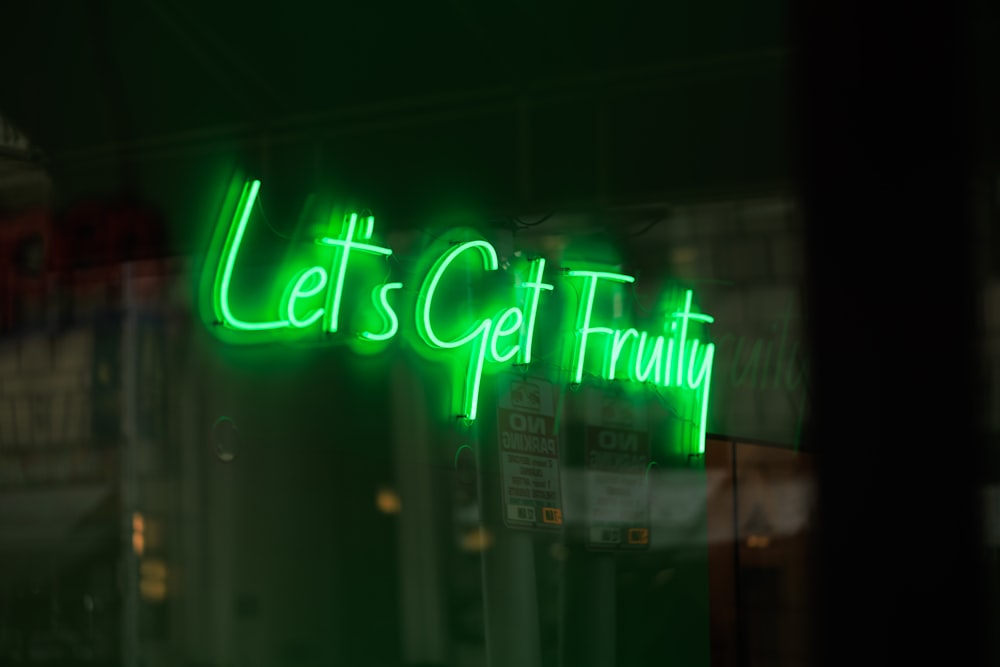 a green neon sign that says let's get fruit