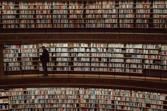 a man standing in front of a large amount of books
