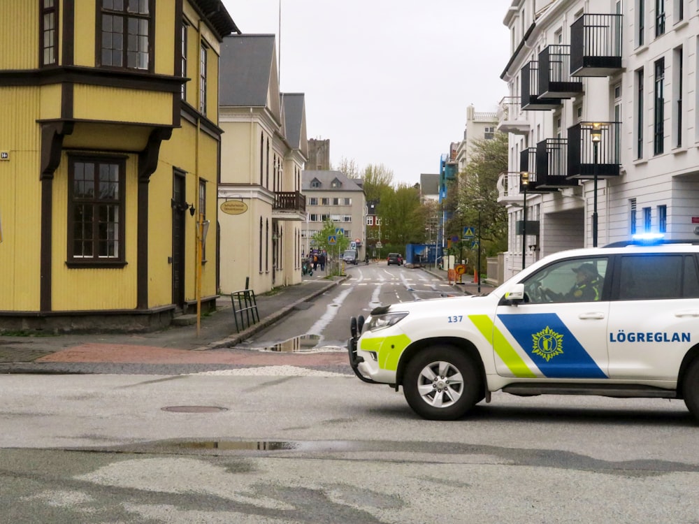 a police car driving down a street next to tall buildings