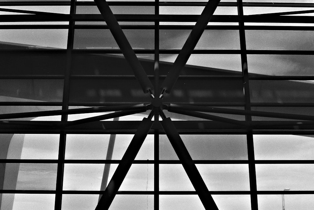 a black and white photo of a window with a sky in the background