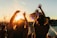 A diverse audience enjoying a lively outdoor concert during sunset.