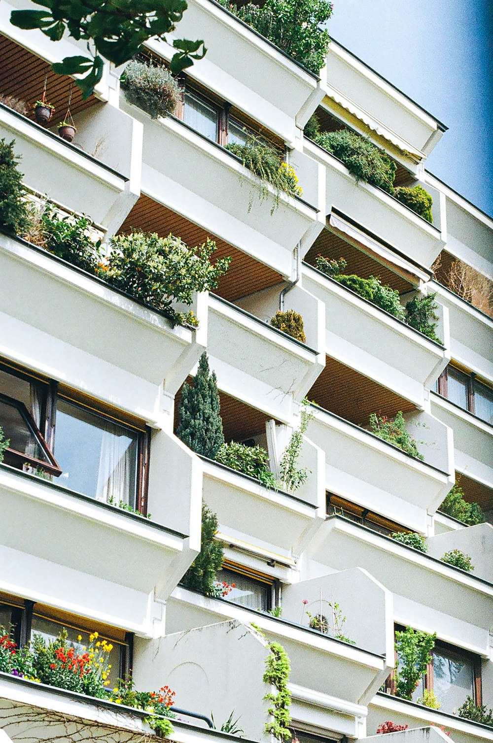 Un edificio muy alto con un montón de plantas en los balcones