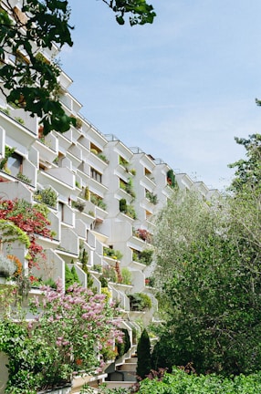 Multifamily housing complex with green terraces and community areas.