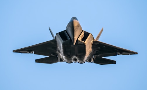 a fighter jet flying through a blue sky