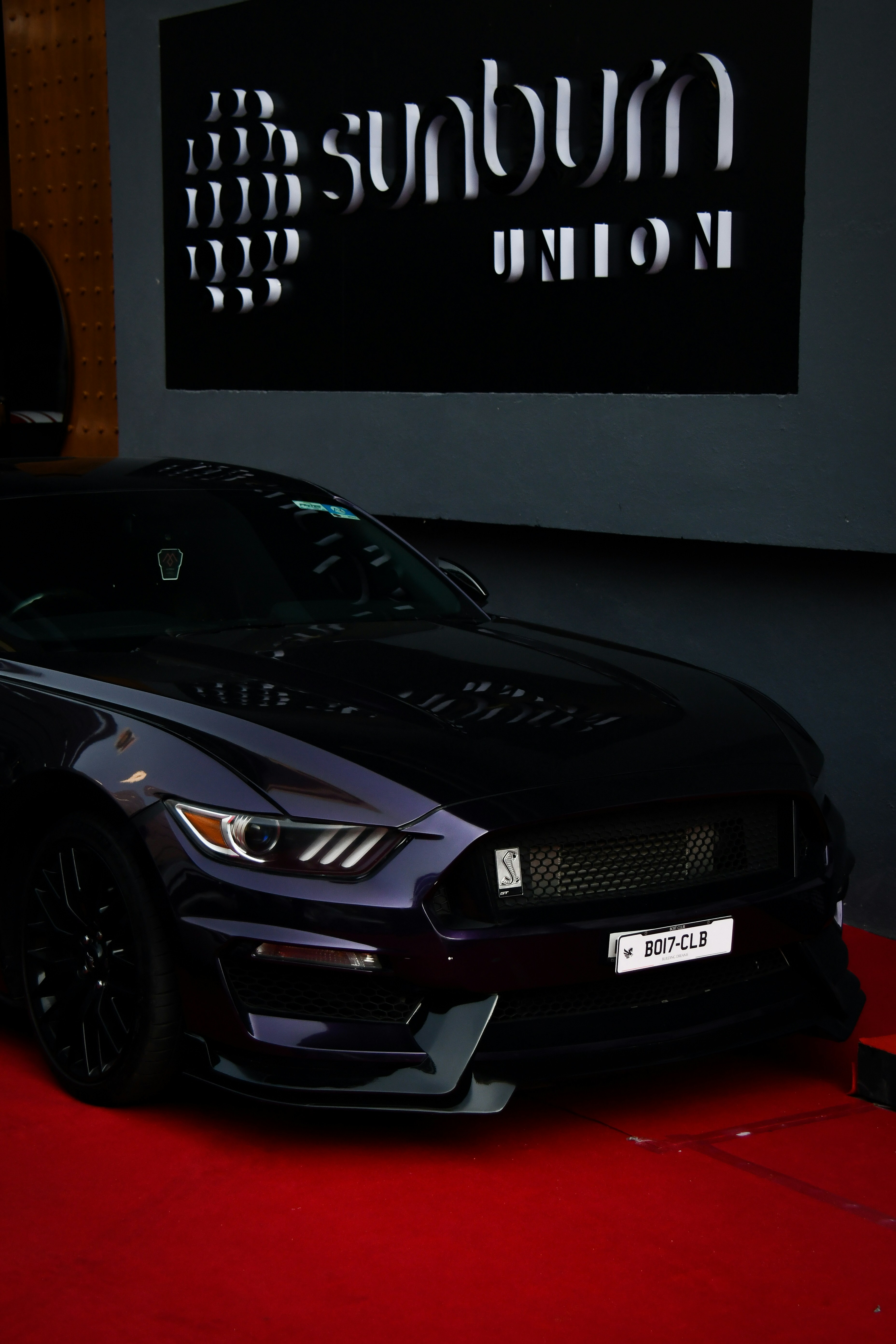 a black car parked in front of a sign