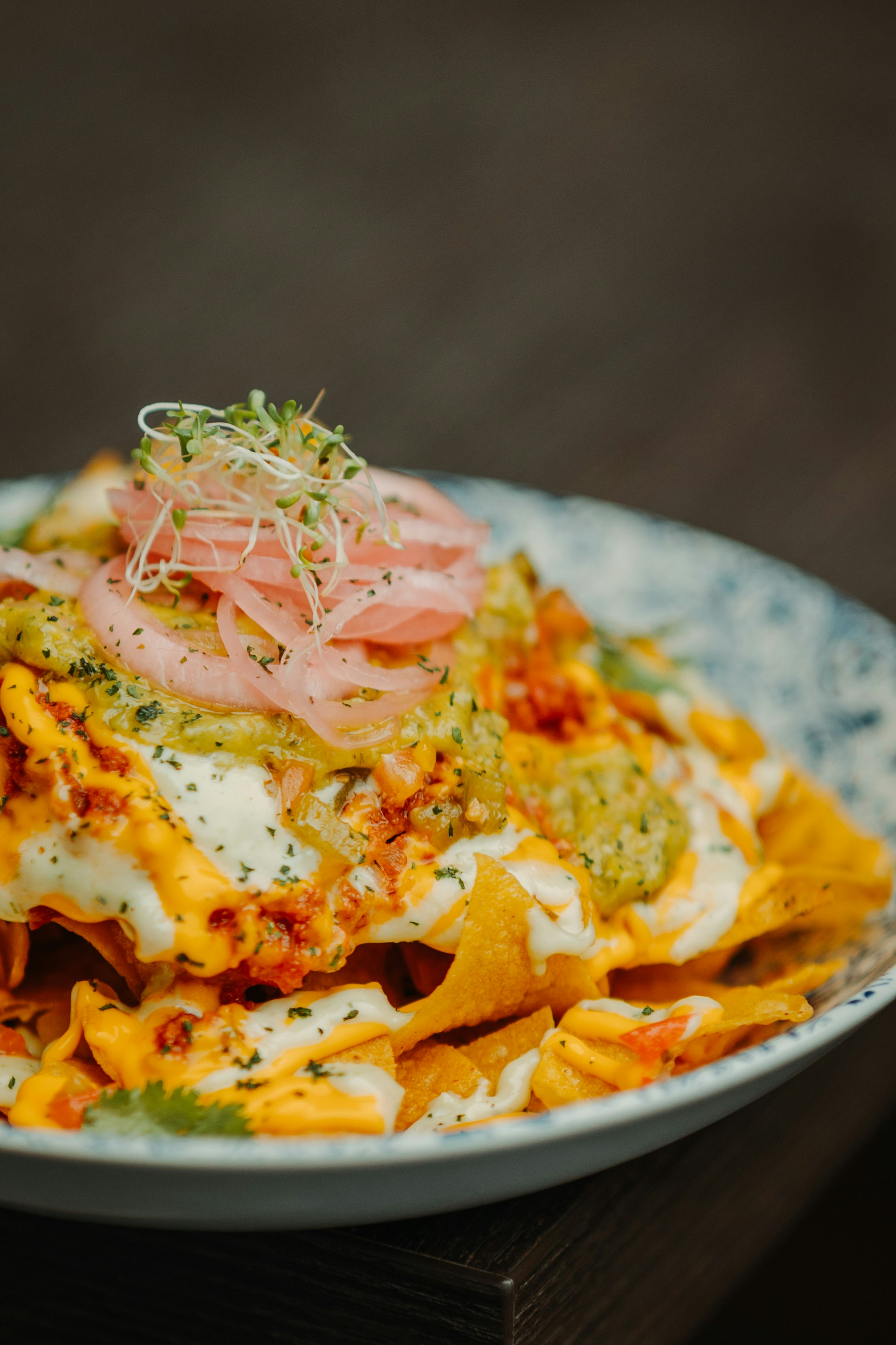 a plate of nachos on a wooden table