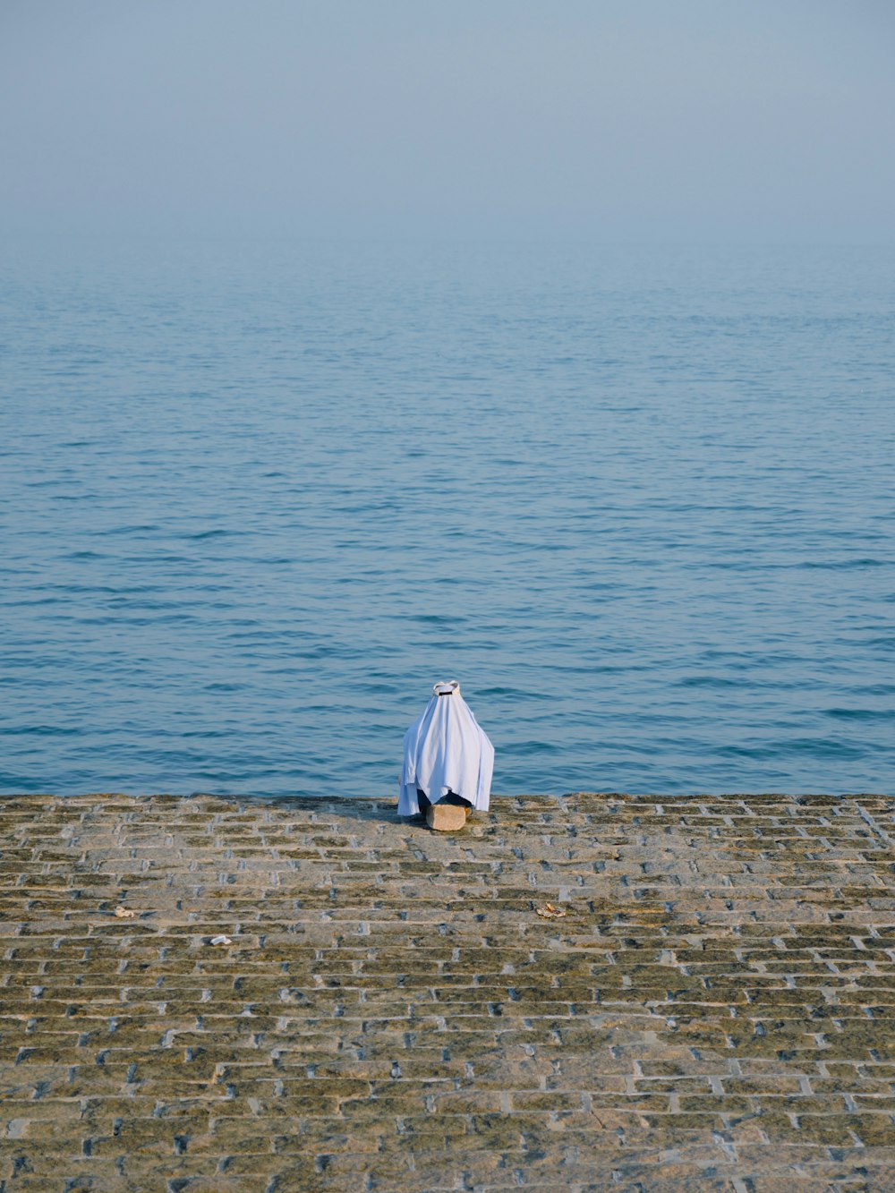 a white umbrella sitting on top of a brick pier