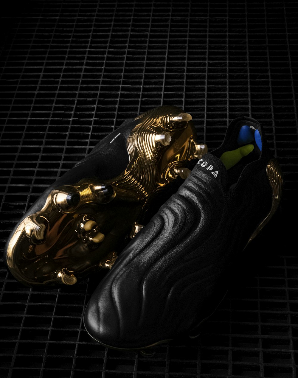 a pair of black and gold shoes on a black surface