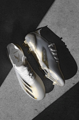 Athlete adjusting modular football boots on a sleek, dark field setting.