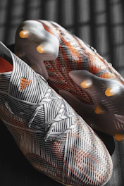 Pair of black football socks with golden stripes on a dark background