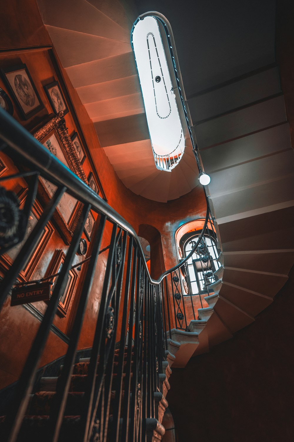 a spiral staircase in a building with a clock on the wall