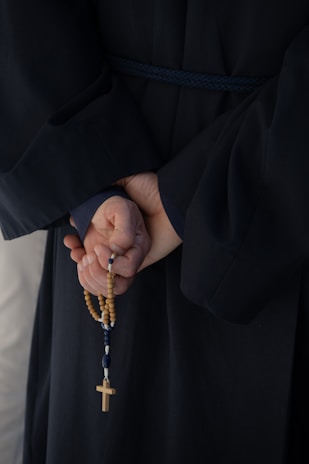 A group gathered in prayerful reflection holding rosaries.
