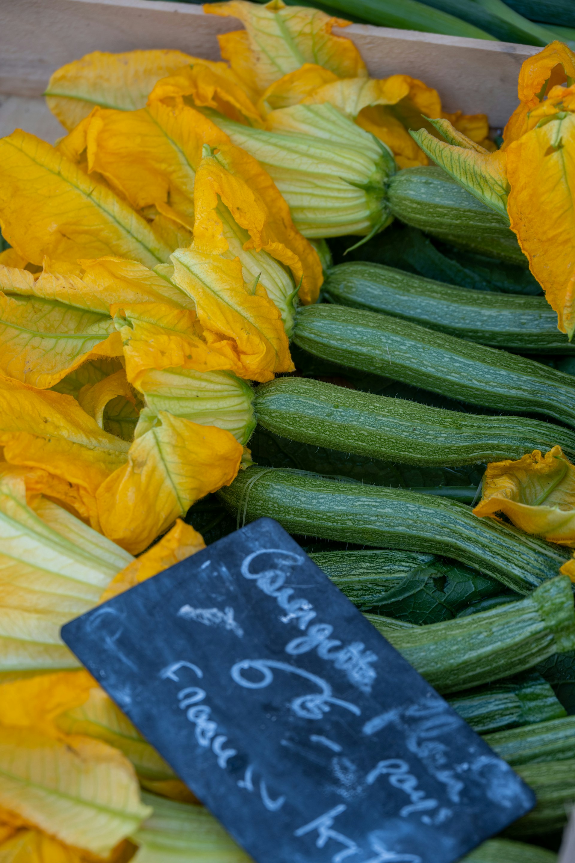 a box filled with cucumbers and yellow flowers