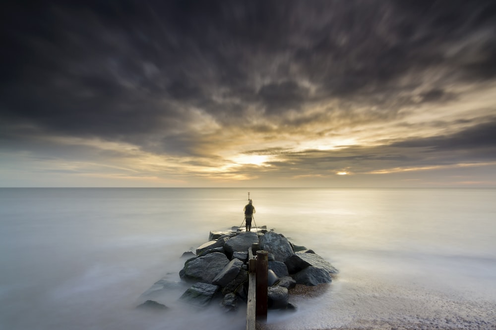 a long exposure photo of a person standing on a pier