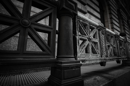 Close-up of intricately designed wrought iron fence with artistic patterns under natural light