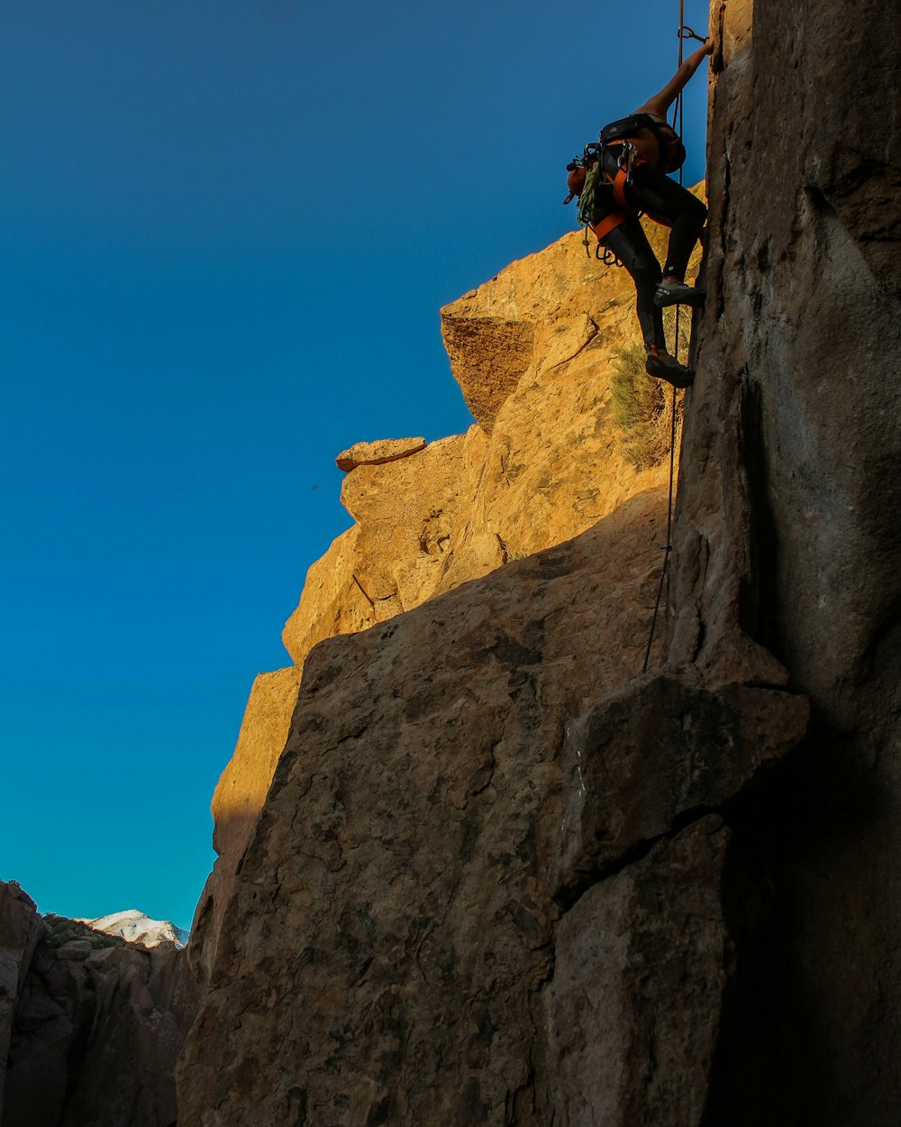 a man climbing up the side of a mountain