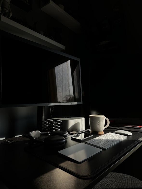 Office desk with computer, paperwork, and a cup of coffee in natural light