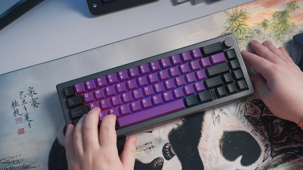 a person is typing on a purple keyboard