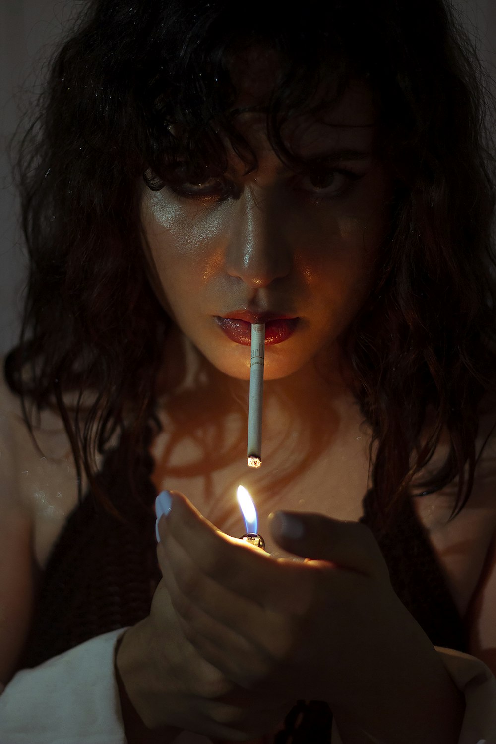 a woman holding a lit cigarette in her hand