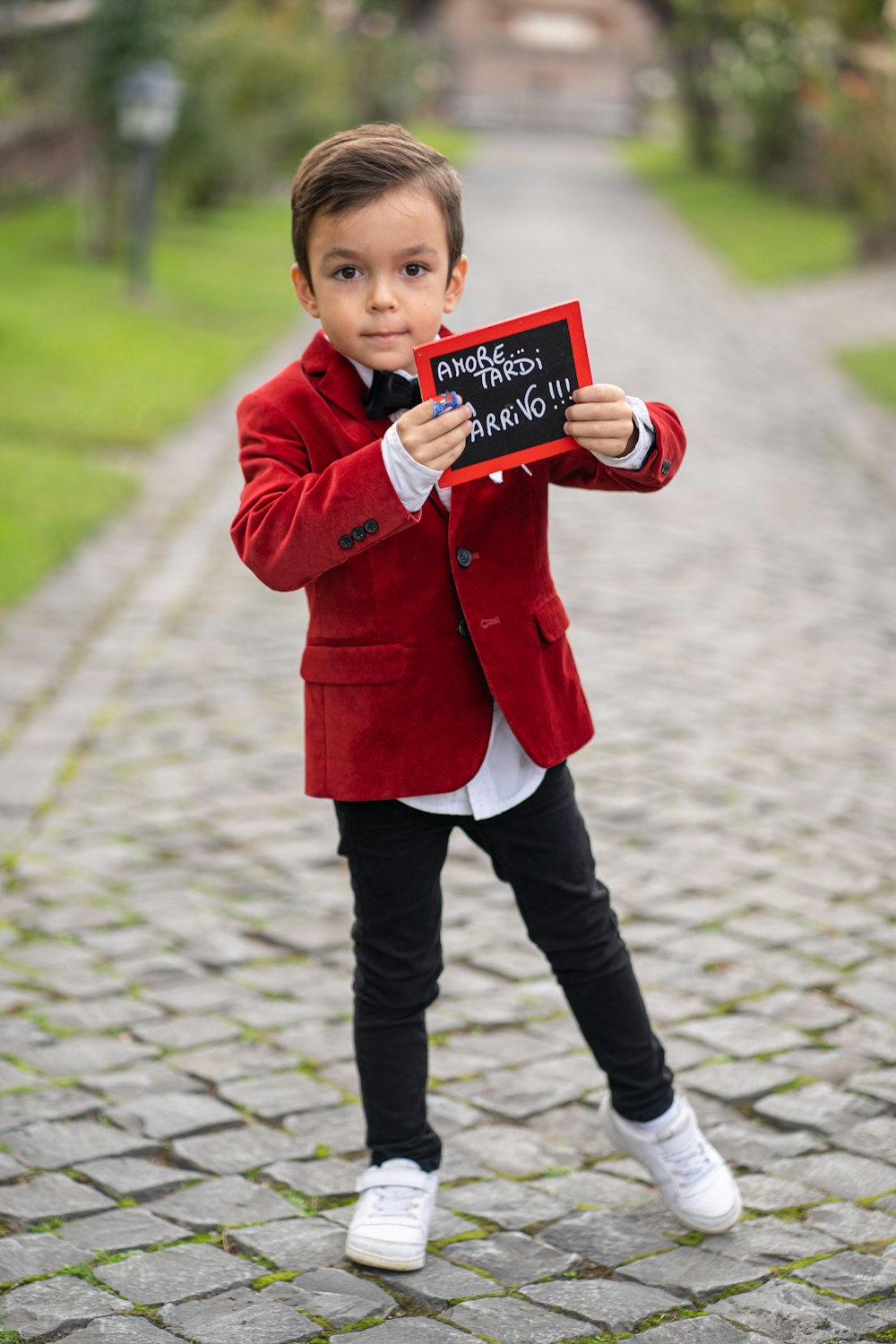 Foto Un niño pequeño con una chaqueta roja sosteniendo un cartel – Imagen  Saco gratis en Unsplash