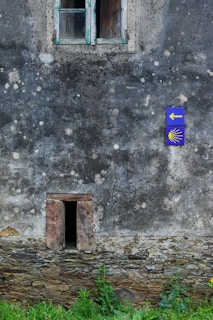 a stone building with a blue sign on it