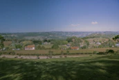 A panoramic view of a peaceful countryside with rolling hills and clear skies.