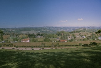 A panoramic view of a custom barndominium nestled among rolling hills and trees in Comal County.
