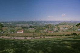 A panoramic view of a peaceful countryside with rolling hills and clear skies.