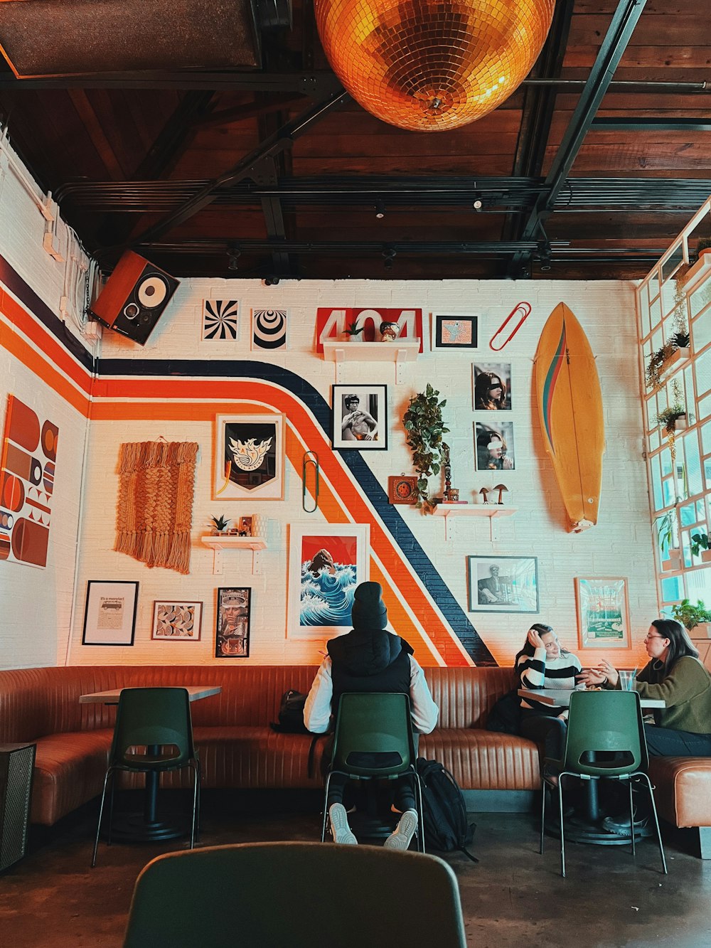 a man sitting at a table with a surfboard on the wall